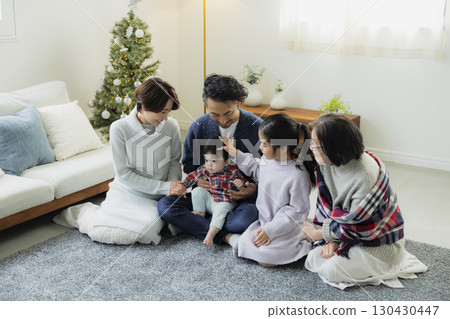 Families decorating Christmas trees 130430447