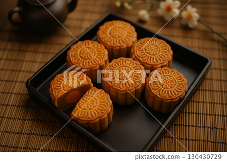 Assorted mooncakes neatly placed on black tray highlighting festive tradition. Moon cake festival concept 130430729
