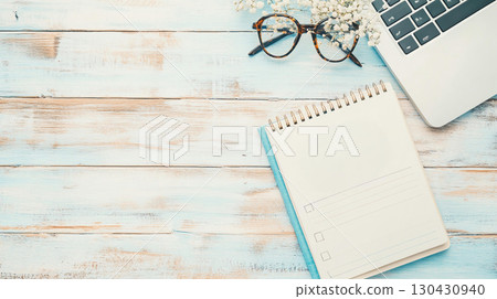 workspace featuring planner, laptop, and glasses on wooden table, perfect for organizing New Year goals and plans. serene setting inspires productivity and creativity workspace featuring planner, laptop, and glasses on wooden table, perfect for organizing New Year goals and plans. serene setting inspires productivity and creativity 130430940