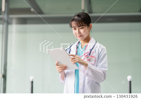 一位年輕的女醫生操作平板電腦 130431926