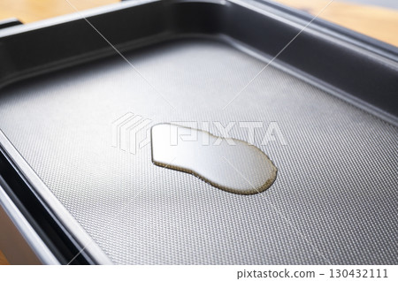 Spread oil on a hot plate 130432111