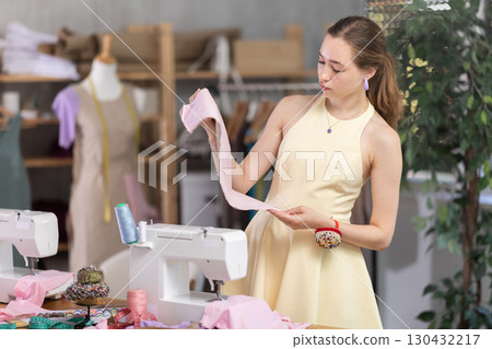 Young woman seamstress with pattern in sewing workshop 130432217