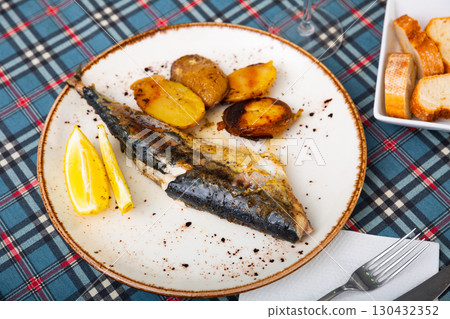 Beautifully served plate of fried mackerel with baked potatoes and lemon Beautifully served plate of fried mackerel with baked potatoes and lemon 130432352