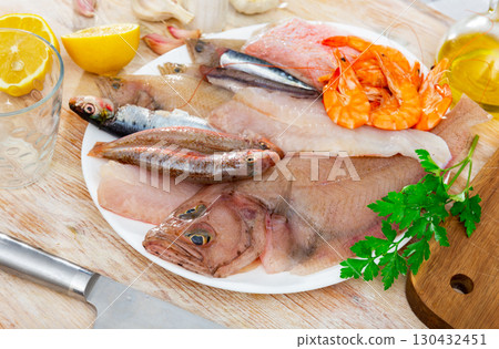 Mix of fish with shrimp served on platter 130432451