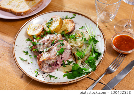 Leg of lamb served with potatoes and onions Leg of lamb served with potatoes and onions 130432538