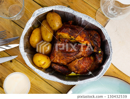 Fried chicken with baked potatoes served in foil Fried chicken with baked potatoes served in foil 130432539