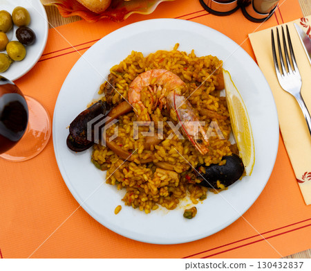Valencian seafood paella - savory rice dish with shrimps, clams and chicken 130432837