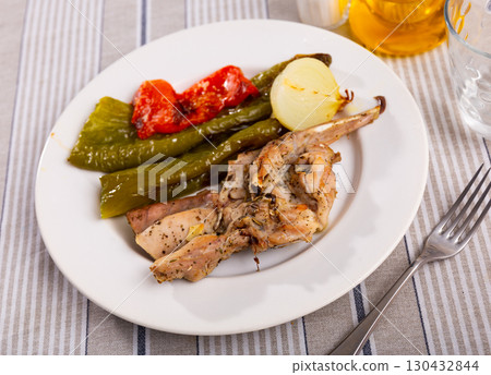 Fried rabbit served with peppers and onions Fried rabbit served with peppers and onions 130432844
