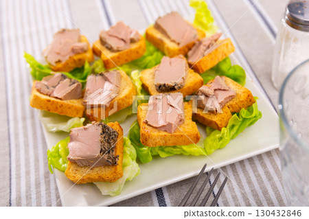 There are sandwiches with meat pate and china cabbage leaves. 130432846
