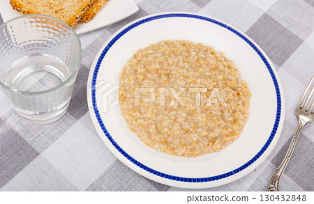 Boiled oatmeal porridge served in plate. Concept of diet food 130432848