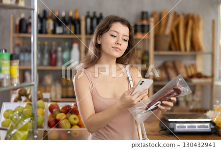 Young woman scanning qr code of dried sausage 130432941