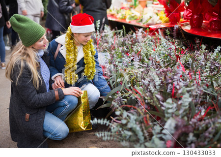 Portrait of woman and her teenage daughter choosing Christmas bouquet of flowers at fair Portrait of woman and her teenage daughter choosing Christmas bouquet of flowers at fair 130433033