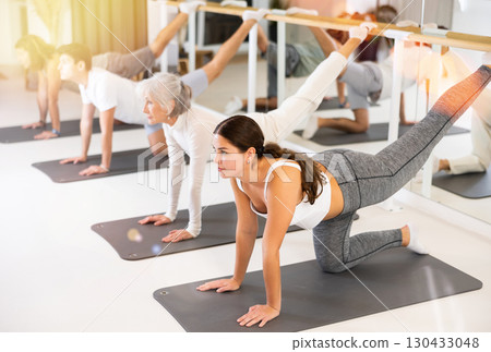 Young woman practicing pilates in gym room 130433048