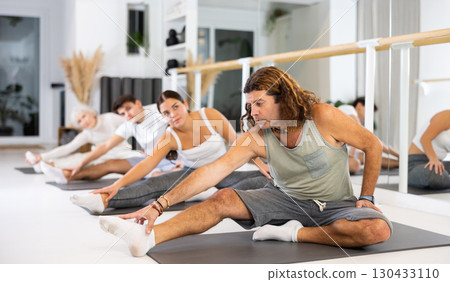 Group of different people doing exercises in gym 130433110