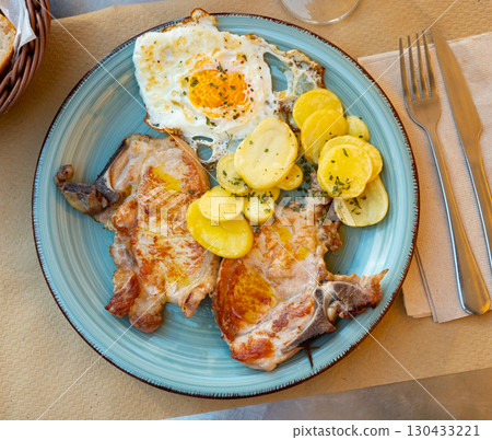 Traditional spanish fried pork with potato and egg on plate. Cerdo patata eggs 130433221