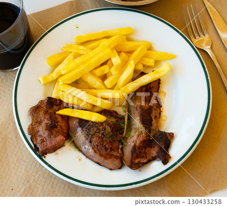 Few pieces of lamb liver are garnished with portion of French fries. Few pieces of lamb liver are garnished with portion of French fries. 130433258