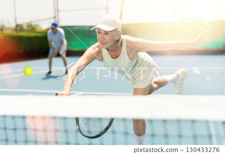 Senior woman plays tennis 130433276
