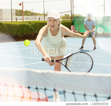 Senior woman plays tennis 130433333