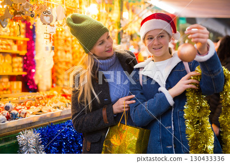 Winter holidays and celebration concept - happy mother and teenager daughter at christmas market closeup Winter holidays and celebration concept - happy mother and teenager daughter at christmas market closeup 130433336