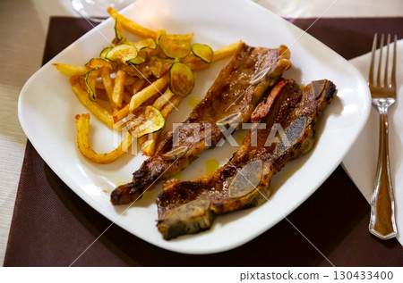 Traditional Spanish dish is Churasco with French fries and zucchini Traditional Spanish dish is Churasco with French fries and zucchini 130433400