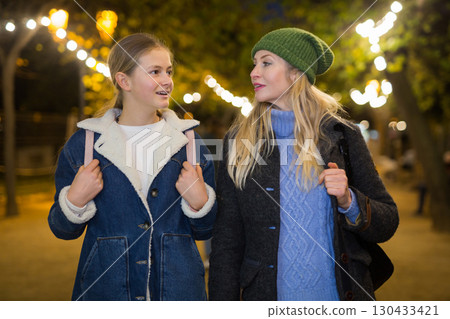 Mother and daughter walking and talking Mother and daughter walking and talking 130433421