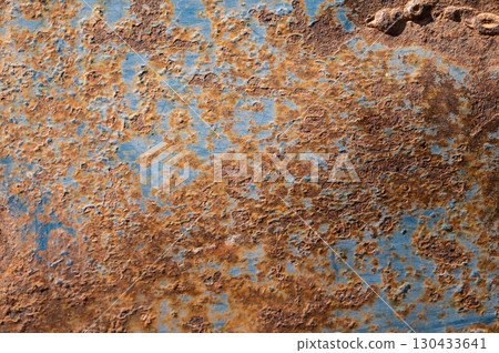 An old rusty metal sheet roof textured. Rust is an iron oxide formed by the reaction of iron and oxygen in the catalytic presence of water or air moisture. 130433641