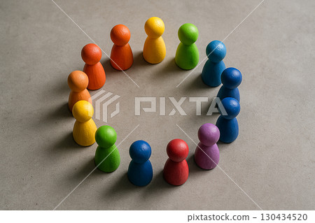 Top view of rainbow wooden peg figures forming symmetrical circle symbolizing equity inclusion and diversity values. Top view of rainbow wooden peg figures forming symmetrical circle symbolizing equity inclusion and diversity values. 130434520