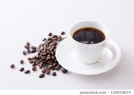 Hot coffee and coffee beans on the table Hot coffee and coffee beans on the table 130434674