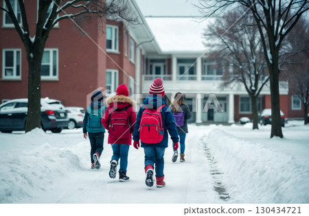 group of children with backpacks walking to school in the snow, education concept group of children with backpacks walking to school in the snow, education concept 130434721