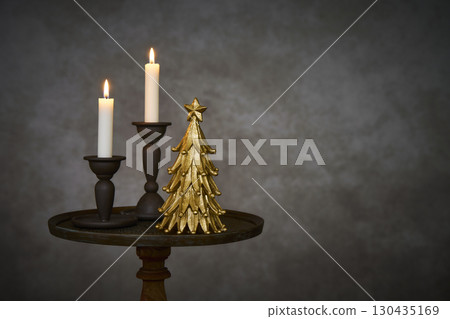 Christmas tree and candle stand on an antique side table Christmas tree and candle stand on an antique side table 130435169