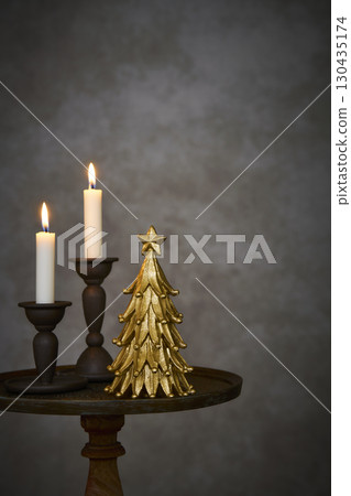Christmas tree and candle stand on an antique side table Christmas tree and candle stand on an antique side table 130435174