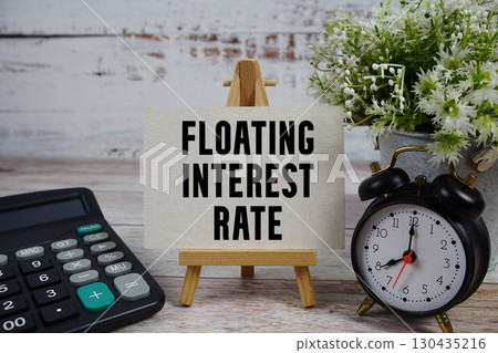 Floating Interest Rate text with alarm clock and calculator on wooden background 130435216