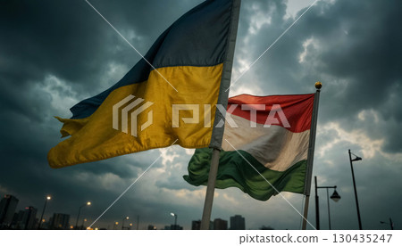 flags of Ukraine and the Hungarian Republic flutter in the wind against a stormy sky 130435247
