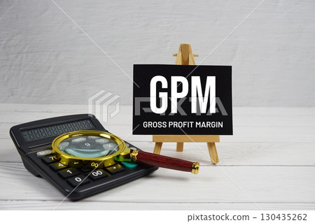 GPM abbreviation of Gross Profit Margin text with magnifying glass and calculator on wooden background 130435262