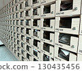 Wooden apartment mailboxes with numbered compartments, organized rows containing letters and documents inside, representing residential communication system, community living, and postal delivery 130435456