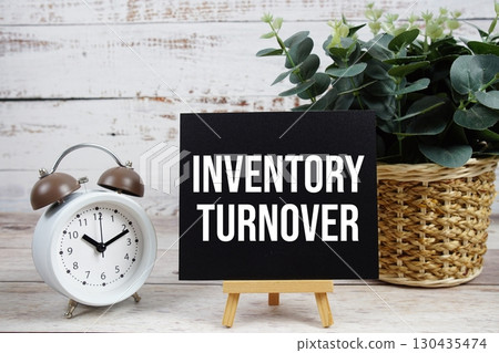 Inventory Turnover text with alarm clock on wooden background Inventory Turnover text with alarm clock on wooden background 130435474