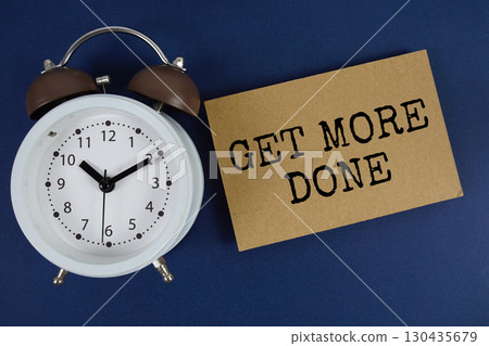 Get More Done text with alarm clock on blue background Get More Done text with alarm clock on blue background 130435679