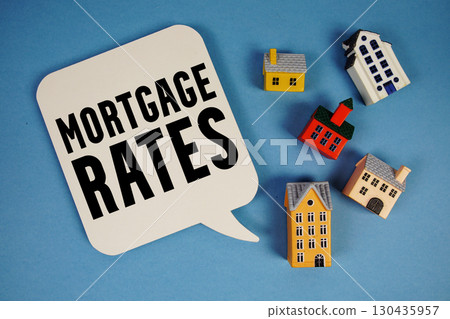 Mortgage Rates text with house models on blue background Mortgage Rates text with house models on blue background 130435957