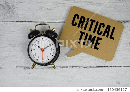 Critical Time text with alarm clock on wooden background Critical Time text with alarm clock on wooden background 130436137