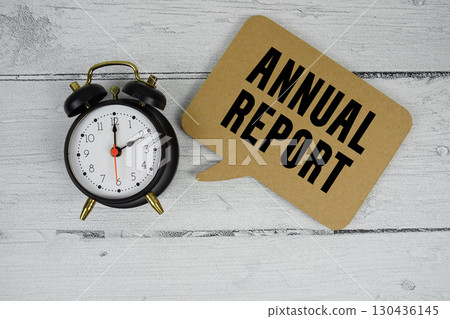 Annual Report text with alarm clock on wooden background Annual Report text with alarm clock on wooden background 130436145