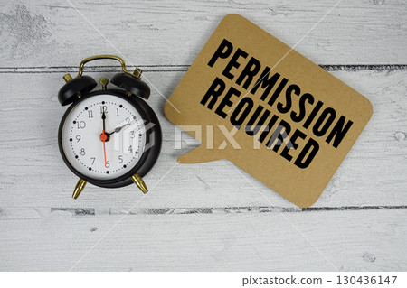 Permission required text with alarm clock on wooden background 130436147