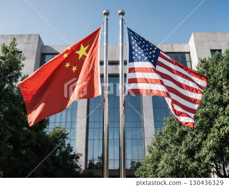 waving usa and china flags in front of modern building, international relations concept 130436329