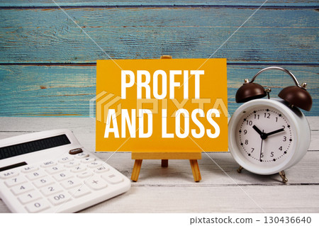 Profit And Loss text written on paper card with calculator and alarm clock on wooden background Profit And Loss text written on paper card with calculator and alarm clock on wooden background 130436640