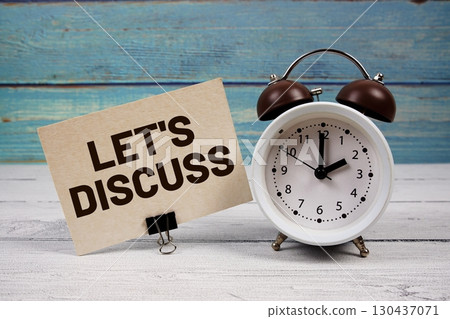 Let's Discuss text written on paper card with alarm clock on wooden background Let's Discuss text written on paper card with alarm clock on wooden background 130437071