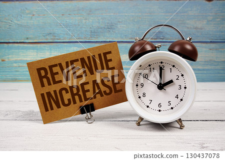 Revenue Increase text written on paper card with alarm clock on wooden background Revenue Increase text written on paper card with alarm clock on wooden background 130437078