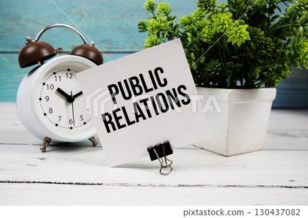 Public Relations text written on paper card with alarm clock on wooden background 130437082