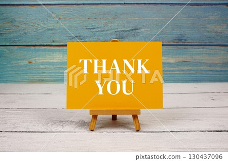 Thank You text written on paper card on wooden background Thank You text written on paper card on wooden background 130437096