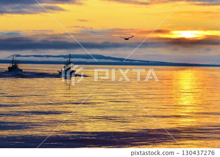 A fishing boat floating in the morning glow sea A fishing boat floating in the morning glow sea 130437276