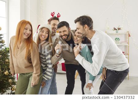 Friends Singing Karaoke Together During A New Year Or Christmas Party At Home 130437332