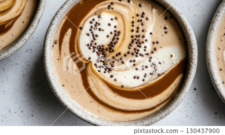 Creamy chocolate and vanilla swirl dessert with chocolate sprinkles in ceramic bowls 130437900